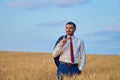 Young farmer businessman in shirt inspects his fields with the harvest