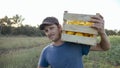 Young farmer going on the field with wooden box of organic bush pumpkin. Royalty Free Stock Photo