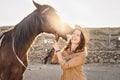 Young farmer having fun with horses inside stable - Happy girl playing with animals in corral ranch Royalty Free Stock Photo