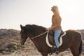 Young farmer woman riding her horse in a sunny day outdoor - Focus on face Royalty Free Stock Photo