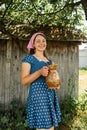 Young farmer woman smiling on camera carries jug of milk after milking cow on farm pasture. Natural dairy products from farmer Royalty Free Stock Photo
