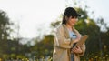 Young farmer woman writing notes while standing in yellow Sunn Hemp flowers field Royalty Free Stock Photo