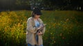 Young farmer woman writing notes while standing in yellow Sunn Hemp flowers field Royalty Free Stock Photo