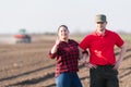 Young farmers examing planted wheat fields