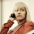 Young fashion blond business woman in red jacket calling on cell phone Royalty Free Stock Photo