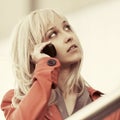 Young fashion blond business woman in red jacket calling on cell phone Royalty Free Stock Photo