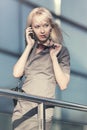 Young fashion business woman talking on mobile phone next to office Royalty Free Stock Photo