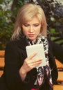 Young fashion blond business woman using digital tablet computer on bench Royalty Free Stock Photo