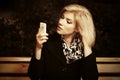 Young fashion blond woman looking at mobile phone Royalty Free Stock Photo