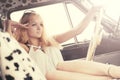 Young fashion blond woman relaxing in vintage car