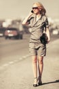 Young fashion blond woman calling on cell phone walking in city street Royalty Free Stock Photo