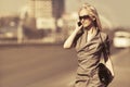 Young fashion blond woman calling on cell phone walking on city street Royalty Free Stock Photo