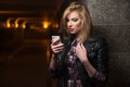 Young fashion blonde woman in leather jacket calling on cell phone Royalty Free Stock Photo
