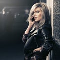 Young fashion blonde woman in leather jacket talking on cell phone Royalty Free Stock Photo