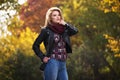 Young fashion blonde woman in black leather jacket and snood scarf Royalty Free Stock Photo
