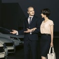 Young fashion business couple collecting new car at dealership lot Royalty Free Stock Photo