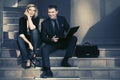 Young fashion business couple with laptop on the steps Royalty Free Stock Photo