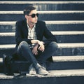 Young fashion business man in sunglasses sitting on the steps Royalty Free Stock Photo