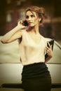 Young fashion business woman with clutch bag calling on cell phone on city street Royalty Free Stock Photo