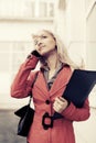 Young fashion business woman with a folder calling on cell phone Royalty Free Stock Photo