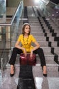 Young fashion business woman with handbag sitting on steps in office Royalty Free Stock Photo