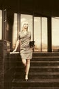 Young fashion business woman with handbag on the steps at office building Royalty Free Stock Photo