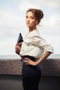 Young fashion business woman with handbag walking on city street Royalty Free Stock Photo