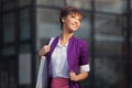 Young fashion business woman in purple blazer with handbag walking at the mall Royalty Free Stock Photo