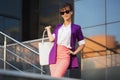 Young fashion business woman in purple blazer and sunglasses with handbag Royalty Free Stock Photo