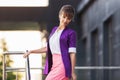 Young fashion business woman in purple blazer walking in city street Royalty Free Stock Photo