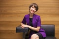 Young fashion business woman sitting on couch in office interior Royalty Free Stock Photo