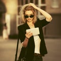 Young fashion business woman in sunglasses using tablet computer on city street Royalty Free Stock Photo