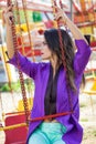 Young fashion caucasian brunette woman portrait sit on flying carousel in amusement park summer Royalty Free Stock Photo