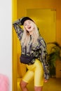 Young fashion girl blogger with black cap on the head dressed in a stylish black and yellow jacket and yellow shorts Royalty Free Stock Photo