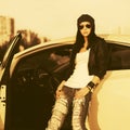 Young fashion hipster woman in sunglasses leaning on her car Royalty Free Stock Photo