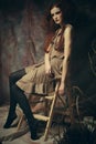 Young fashion model with creative make up sitting on a stool in Royalty Free Stock Photo