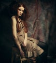 Young fashion model with creative make up sitting on a stool in Royalty Free Stock Photo