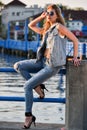 Young fashion model posing pretty on the pier. Royalty Free Stock Photo