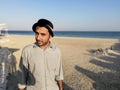 A young fashion model is posing at a sandy beach and sea in background Royalty Free Stock Photo