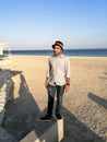 A young fashion model is posing at a sandy beach and sea in background Royalty Free Stock Photo