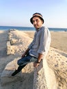 A young fashion model is posing at a sandy beach and sea in background Royalty Free Stock Photo