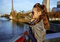 Young fashion-monger speaking on smartphone near Eiffel tower Royalty Free Stock Photo