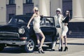 Young fashion people outside a vintage car