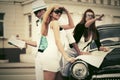 Young fashion people with a road map next to vintage car Royalty Free Stock Photo