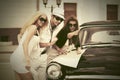 Young fashion people with a road map next to vintage car Royalty Free Stock Photo