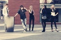 Young fashion people using cell phones on city street Royalty Free Stock Photo