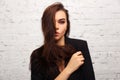 Young fashion woman in black jacket next to brick wall Royalty Free Stock Photo