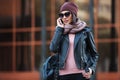 Young fashion woman in black leather jacket using cell phone in city street Royalty Free Stock Photo