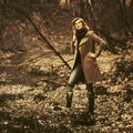 Young fashion woman in classic beige coat walking in autumn forest Royalty Free Stock Photo