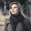 Young fashion woman in classic beige coat walking in autumn park